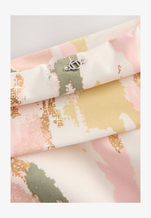 Wielokolorowa tkanina z wzorem malowanych pociągnięć pędzla w pastelowym różu, zieleni i żółci, z akcentami złota oraz małym srebrnym logo.