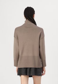 Brauner, gestrickter Rollkragenpullover mit langen Ärmeln, gerippten Akzenten an den Bündchen und dem Saum, leicht lockere Passform, von hinten gezeigt.