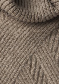 Světle béžový pletený rolák s ribovanými a diagonálními vzory, s měkkou strukturou a silným stočeným límcem.