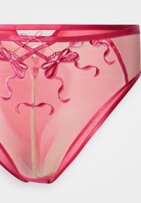 Ροζ διαφανές εσώρουχο με κεντητά φιόγκους και στροβιλισμούς. Σατινένιο περίγραμμα στη μέση και στις ανοίγματα των ποδιών. Ελαφρύ ύφασμα από δίχτυ.