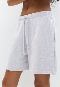 Shorts in cotone grigio chiaro con fascia elasticizzata in vita, cordoncino regolabile e tasche laterali. Tessuto liscio e vestibilità rilassata.