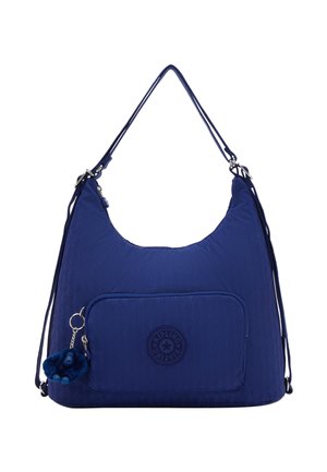 Navy blue shoulder bag with front zip pocket, adjustable straps, and a small plush monkey keychain attached to the zipper.