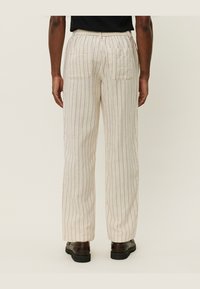Pantalons en mélange de lin couleur crème, avec des rayures verticales, dotés d'une taille élastique, de deux poches arrière et d'une coupe droite.