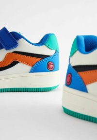 Baskets bleues et teal avec des accents orange et noir, fabriquées en matériau synthétique. Présentent un logo de visage souriant et une semelle texturée.