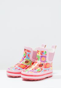 Kleurige rubberen regenlaarzen met een roze basis, voorzien van een patchworkontwerp van bloemen, sterren en harten. Elastische zijpanelen voor eenvoudig aan- en uittrekken.