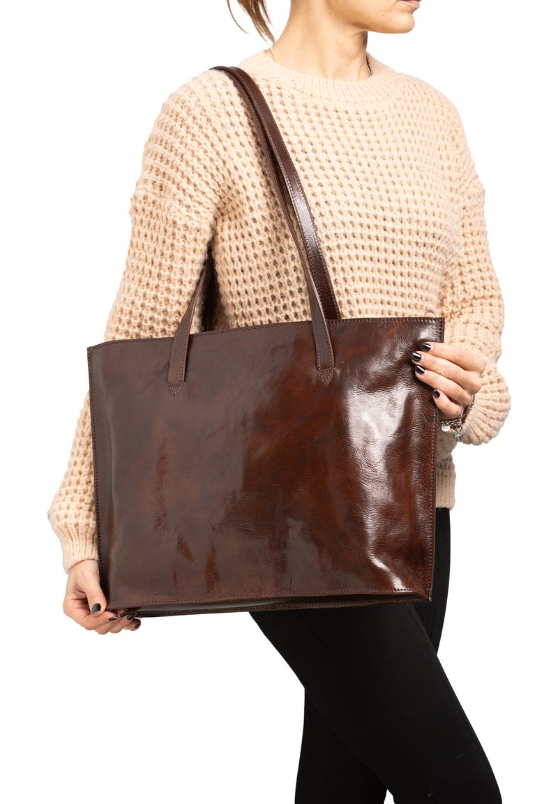 Bruin leren draagtas met een glanzende afwerking, beschikt over lange handgrepen, een rechthoekige vorm en minimale hardware voor een strakke uitstraling.