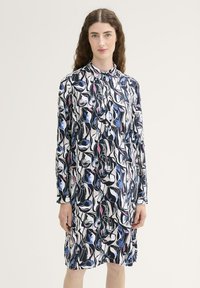 Langemouwenjurk met een gedurfde abstracte print in zwart, wit en blauw. Gemaakt van gladde stof met een kraag en knoopsluiting.