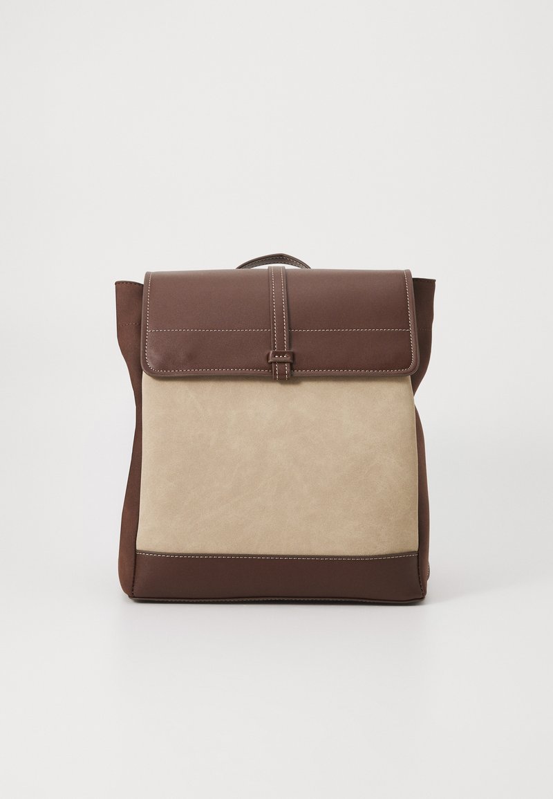 Sac à dos brun et beige avec un design structuré, doté d'une fermeture à rabat, de coutures verticales et d'un panneau en tissu texturé.