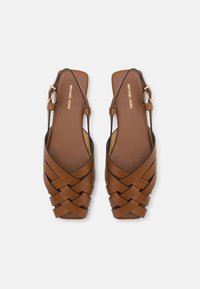 Pantofi slingback din piele maro, cu design țesut, talpă plată și accente cu cataramă aurie. Textură netedă și stil minimalistic.