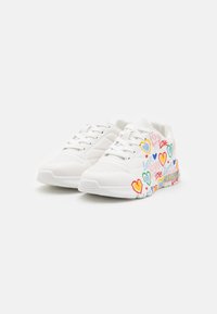 Weiße Sneaker mit bunten Herzmustern und dem Text "Liebe". Hergestellt aus glattem Material mit einer perforierten Textur und einer gepolsterten Sohle.