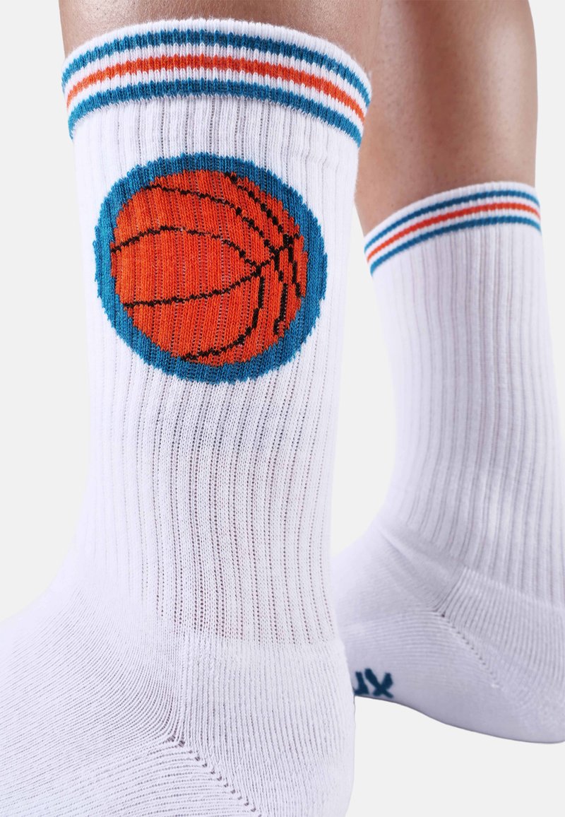 Weiß gerippte Socken mit einem orangefarbenen Basketball-Design, das von Blau umkreist wird. Akzente durch blaue und orangefarbene Streifen am Bündchen. Material aus Baumwollmischung.