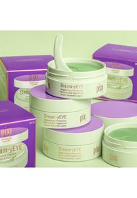 Dream-yEYE Augenmasken in runden weißen Behältern mit lilafarbenen Deckeln, ausgestattet mit grünen Gel-Patches und einem kleinen Spatel zur Anwendung.