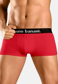Bóxers rojos ceñidos con una cinturilla elástica negra que presenta la marca "bruno banani" en blanco. Tela suave, diseño ajustado y largo hasta el muslo.
