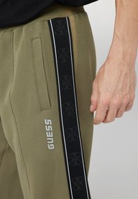 Guess JOGGING SEITLICHES LOGO - Treningo apatinė dalis - verde oliva