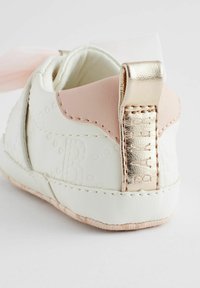 Witte leren schoen met een zachtroze leren accent en een gouden metallic hielpaan. Voorzien van een geperst logo en een zachte binnenvoering.