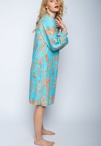 Lockeres, blaues Kleid mit floralen und blättrigen Mustern in Orangetönen. Lange Ärmel mit Manschetten, knielang, aus leichtem Stoff gefertigt.