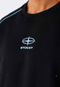 Sudadera negra con costuras de acento azules alrededor del escote y un logotipo bordado en un azul claro prominente en el pecho.