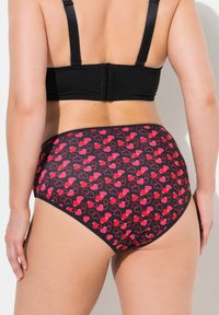 Costume da bagno a vita alta in nero, con un motivo di cuori rossi. Realizzato in tessuto morbido, con un design senza cuciture e una vita elastica.