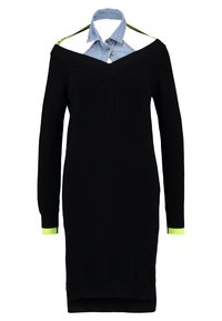 Svart stickad klänning med off-shoulder design, prydd med en ljusblå denimkrage och neongröna detaljer vid ärmarna. Långa ärmar, figurnära silhuett.