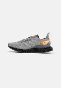 Sneaker grigio Adidas con suola a reticolo 3D nera, accentuazione arancione sul tallone, tre strisce laterali e tomaia in maglia con lacci, vista laterale.