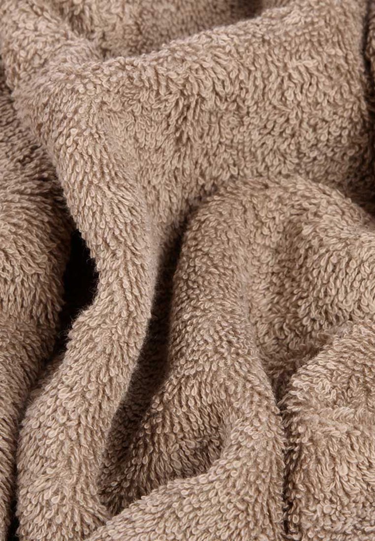 Tissu en éponge marron avec une surface texturée et pelucheuse ; le matériau semble doux et est disposé en plis lâches.