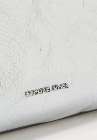 Portafoglio in pelle argento con una finitura testurizzata. Presenta un logo prominente in lettere argentate incastonato sulla superficie.