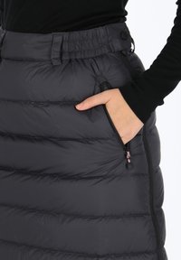 Mustat puffihameet, joissa on tikattu muotoilu, joustava vyötärö ja sivu-zip-taskut. Ominaisuuksiin kuuluu sileä pinta ja kontrastivärit vetoketjut.