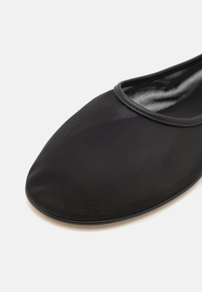 Ballerine noire en tissu texturé avec un bout arrondi et une doublure lisse et brillante, comportant un décor subtil autour de l'ouverture.