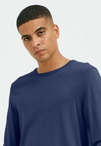 Jūras spēku garās piedurknes T-krekls, apaļa kakla izgriezums, maiga tekstūra, brīvi pieguļošs, ar smalku šuvju detaļu uz piedurknēm.