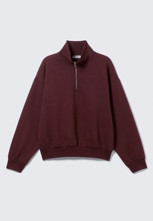 Burgundy pulóver kapucnis sweatshirt, puha anyagból, magas gallérral, félig cipzárral és bordázott mandzsettákkal és aljjal. Lazább szabású dizájn.