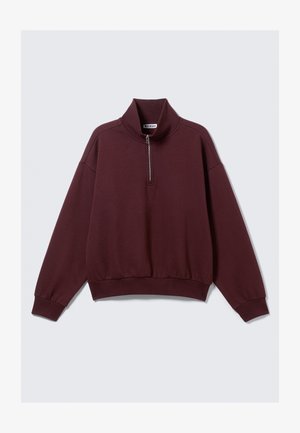 Burgundy pullover sweatshirt made of soft fabric, featuring a high collar, half zip, and ribbed cuffs and hem. Relaxed fit design.