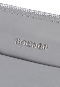 Gray nylon pouch with silver zipper and embossed "BOGNER" logo. Smooth texture and minimalist design, featuring clean lines and no patterns.