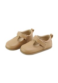 Zapatos Mary Jane de cuero beige con bordes festoneados, correa ajustable y suelas de goma. Textura suave con un diseño de punta redonda.