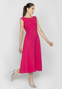 Magenta lniana sukienka z dopasowanym górą, bez rękawów i spódnicą w kształcie litery A. W zestawieniu ze światło niebieskimi sandałami na obcasie.