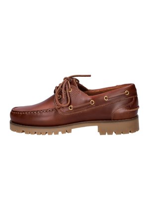 Bruine leren boot schoen met veterluiting aan de voorkant, messing oogjes, moc toe stiksels en een robuust rubberen zool, getoond vanaf de linkerkant.