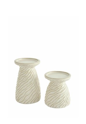 Due portacandele in ceramica torsionata color crema, uno più alto e uno più basso, con motivi ondulati e testurizzati sui loro corpi.