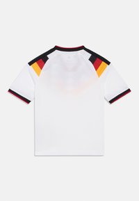 Camisa desportiva branca de mangas curtas, com detalhes multicoloridos em preto, vermelho e amarelo nos ombros. Textura de tecido suave.