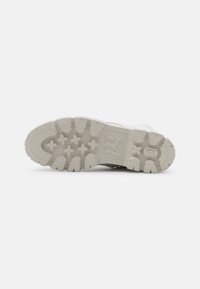 Suela blanca de zapatilla deportiva con goma texturizada, que presenta patrones de tracción distintivos y un logotipo grabado en el lateral.
