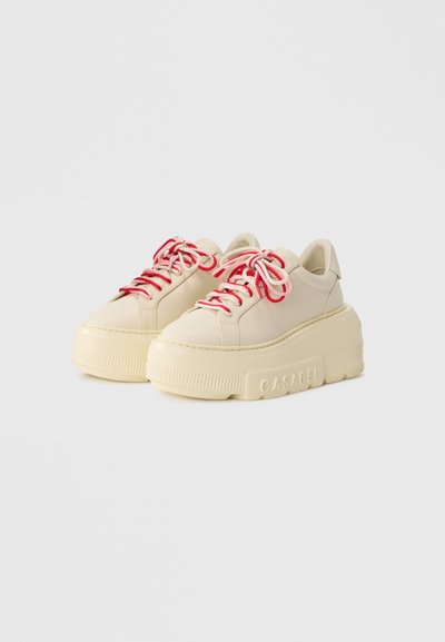 Χοντρά sneakers με πάτο πλατφόρμα από κρεμ δέρμα και υφασμένο λαστιχένιο πέλμα. Διαθέτουν κορδόνια με ροζ και κόκκινες ρίγες και στρογγυλεμένο σχέδιο μύτης.