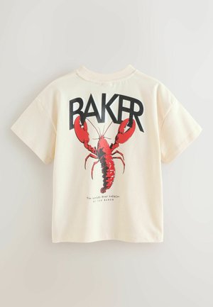 Bavlnené tričko krémovej farby s veľkou červenou grafikou homára a výrazným čiernym nápisom "BAKER" nad ním s ďalším textom pod ním.