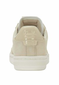 Sneaker en daim beige avec semelle en caoutchouc blanc, col rembourré et "K-Swiss 1966" en relief sur l'onglet du talon, vue de l'arrière.