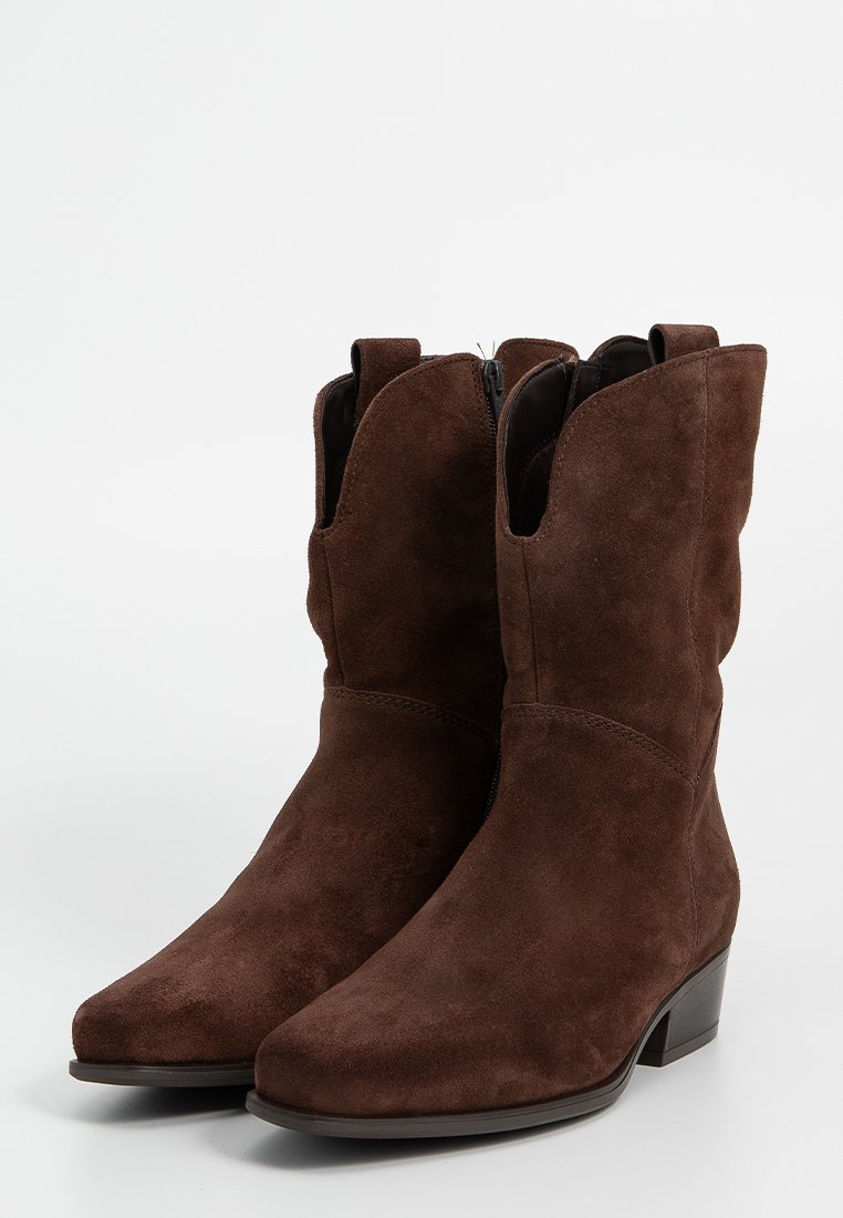 Ein Paar mittelhohe braune Wildleder-Cowboystiefel mit niedrigen, gestapelten Absätzen und seitlichen Ziehlaschen auf einem weißen Hintergrund.