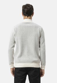 Strickpullover in Off-White mit vertikalen Streifen, gerippten Bündchen und Saum. Figurbetonter Schnitt mit einer dezenten Textur, ausgestattet mit einem klassischen Kragen.