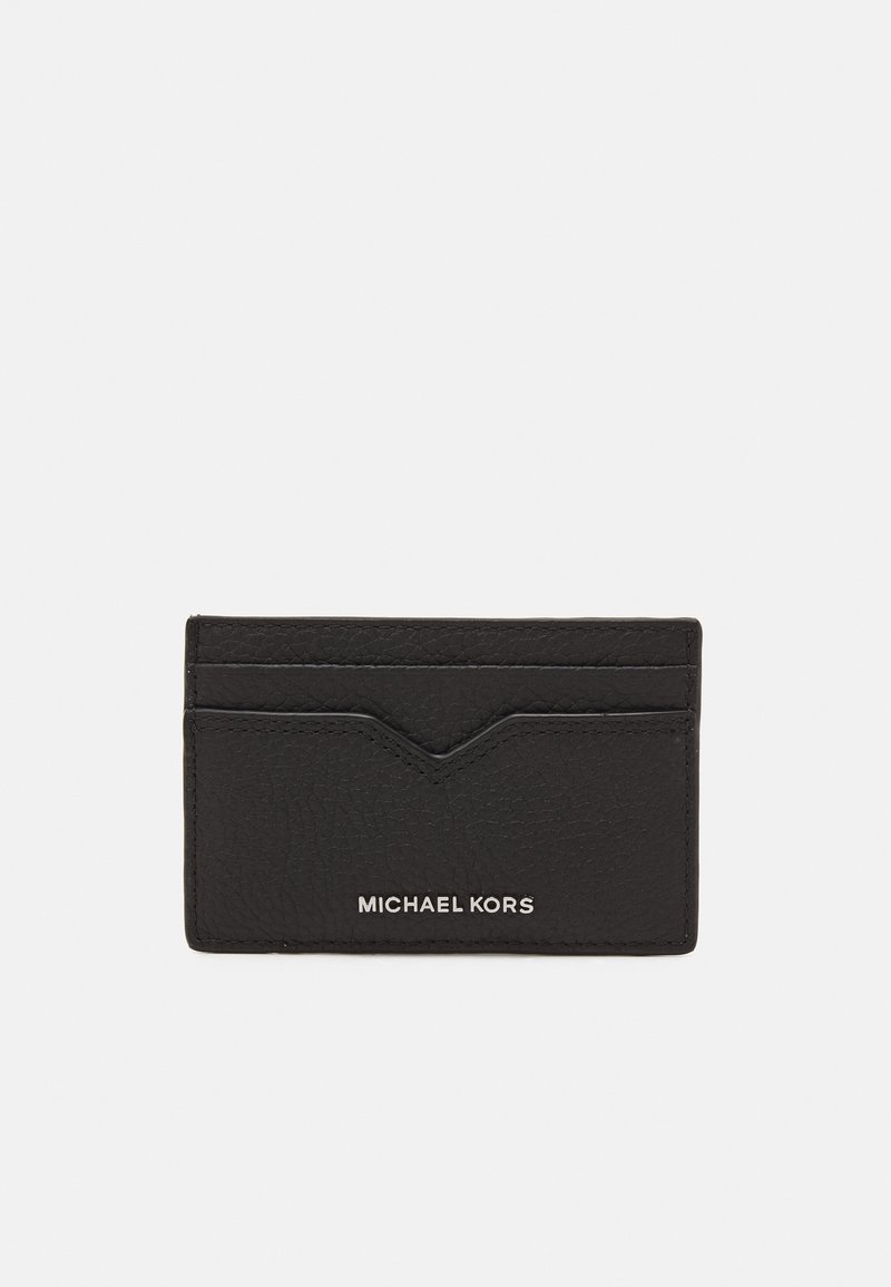 Porte-cartes en cuir noir avec surface texturée, comportant cinq fentes et un accent en chevron. "MICHAEL KORS" embossé en bas.