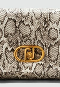 Textūruotas gy snake odos piniginė šviesiai ruda ir ruda spalvų derinyje, su ovaliu auksinės spalvos užsegimu, kuriame yra logotipo detalė, pabrėžianti sudėtingą raštą.