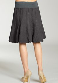 Grauer Leinenrock mit einem breiten grauen Bund, knielang und ausgestelltem Schnitt, kombiniert mit beigen High Heels, die eine glatte Textur zeigen.