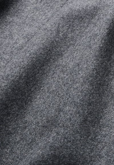 Tessuto grigio in feltro con una texture morbida, caratterizzato da un pattern uniforme e sottili variazioni di tonalità. Nessun elemento di design prominente o hardware.