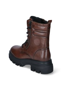 Bottines en cuir marron avec une semelle en caoutchouc noir robuste, lacets à l'avant, fermeture éclair sur le côté et détail de logo embossé. Panneaux texturés sur la tige.