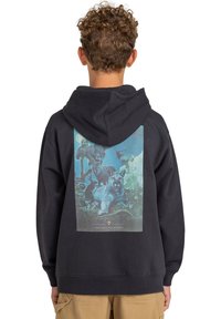 Sudadera negra con un gráfico texturizado en la parte posterior que representa fauna salvaje. Cuenta con capucha, puños acanalados y un mensaje sobre la prevención de incendios forestales.