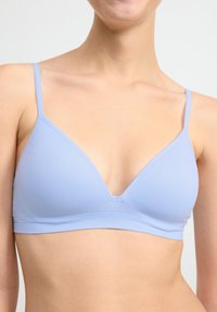Bralette triangular de color azul claro con tirantes finos, textura lisa y diseño sin costuras. Ideal para comodidad y soporte sutil.
